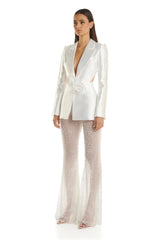 Woman wearing a white blazer and patterned pants