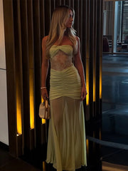 Woman in a light green dress standing indoors with a blurred background