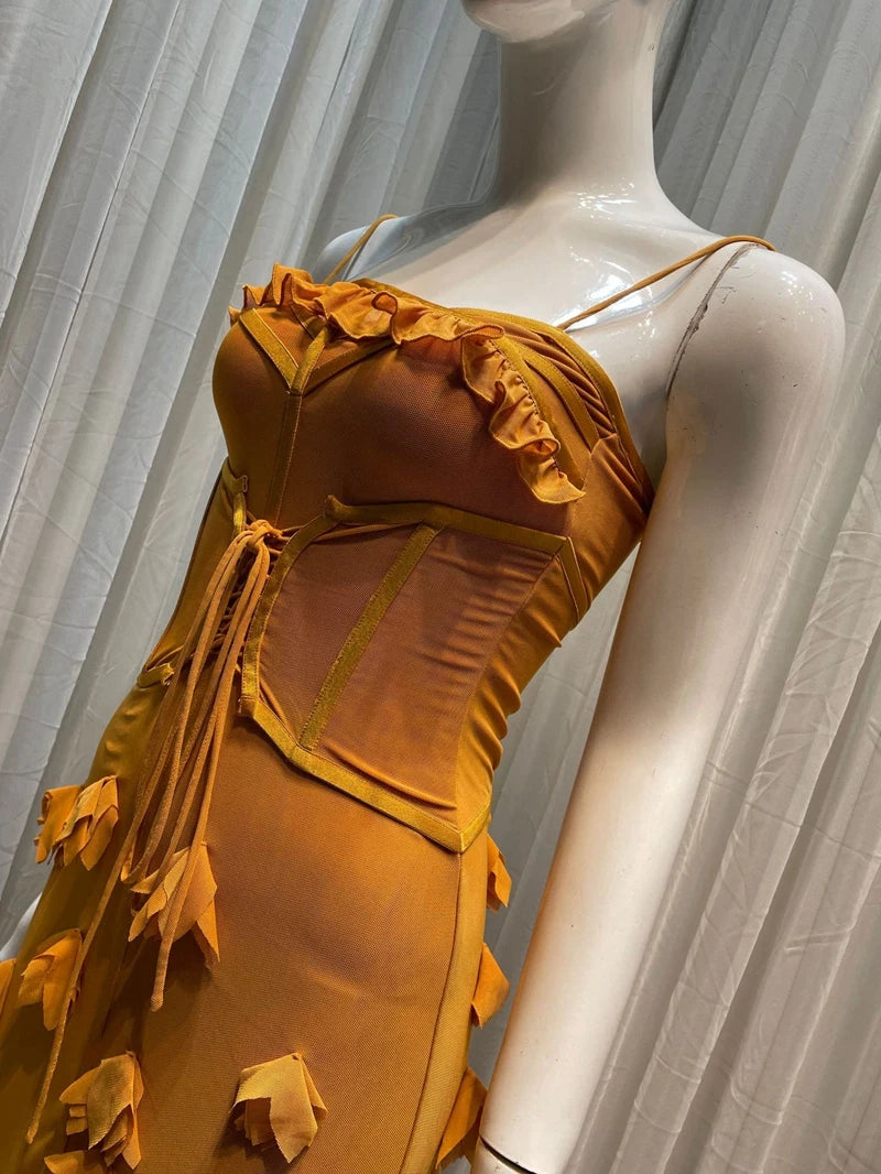 Yellow ruffled dress on a mannequin against a neutral background