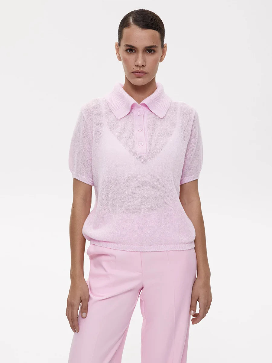 Person wearing a light pink polo shirt and pants on a white background
