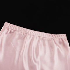 Close-up of pink pants with a black background