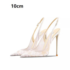 White high-heeled shoes with gold accents on a white background