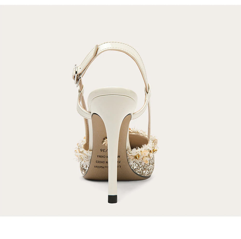 White high-heeled sandal with decorative sole on a light gray background