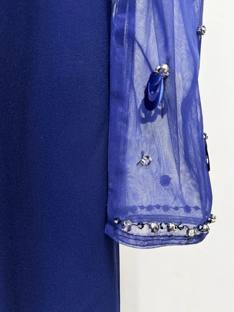 Close-up of a blue garment with decorative elements on a white background