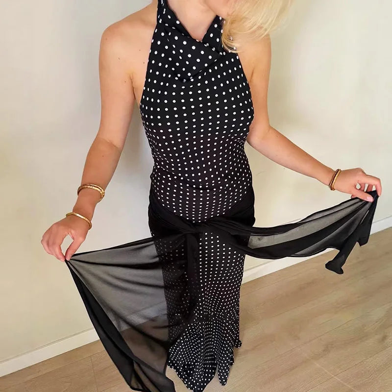 Woman wearing a black and white polka dot dress with sheer black fabric.