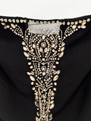 Close-up of the intricate beadwork on the neckline of a black maxi dress.