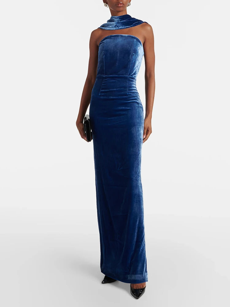 Woman wearing a blue velvet halter neck gown on a white background