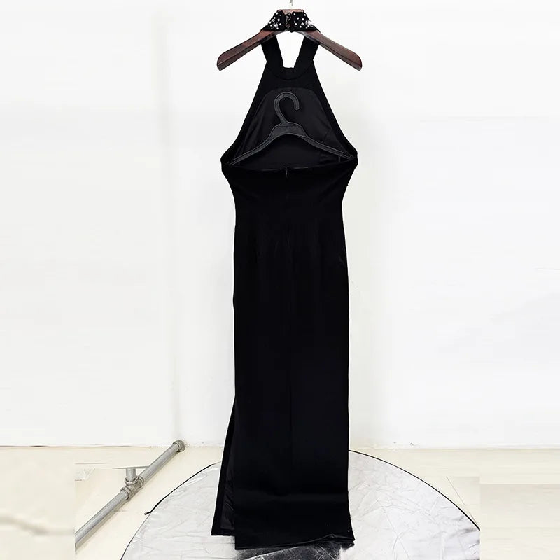 Black dress on a hanger against a white background