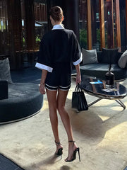 Woman in a stylish outfit standing in an indoor setting with modern decor.