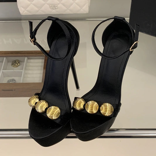 Platform stiletto sandal in black with gold embellishments