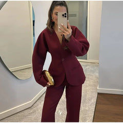 Person wearing a burgundy suit taking a mirror selfie.