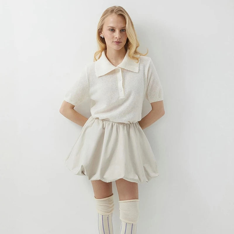 Woman wearing a white outfit with a plain background