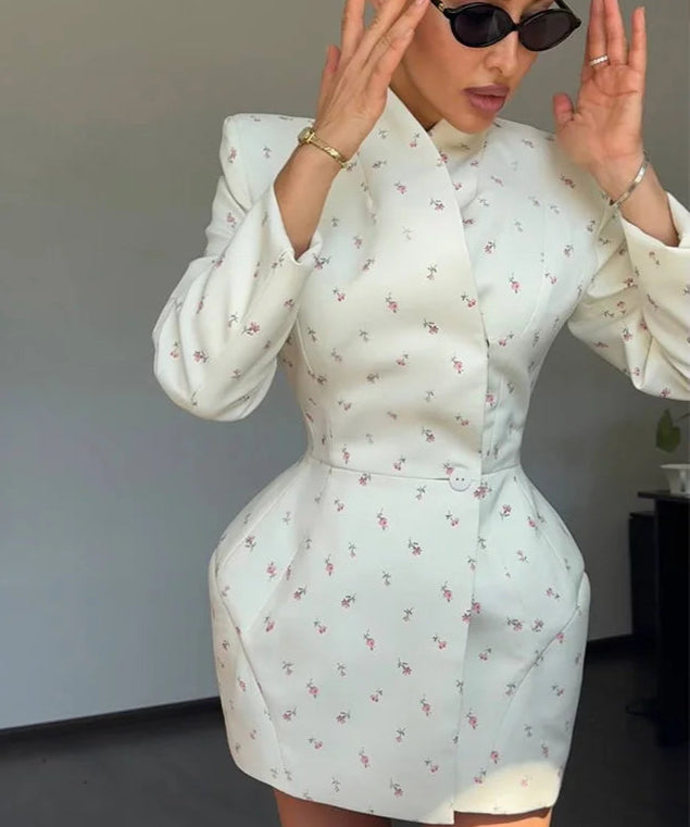 Woman wearing a light blue floral dress with long sleeves in an indoor setting.