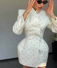 Woman wearing a light blue floral dress with long sleeves in an indoor setting.