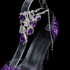 Jeweled high-heeled shoe with purple and clear stones on a black background