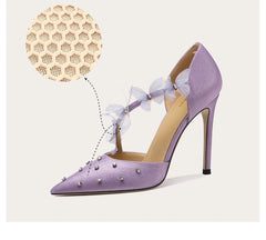 Purple high-heeled shoes with decorative elements on a light background