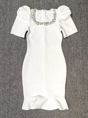 White dress with embellishments on a gray background