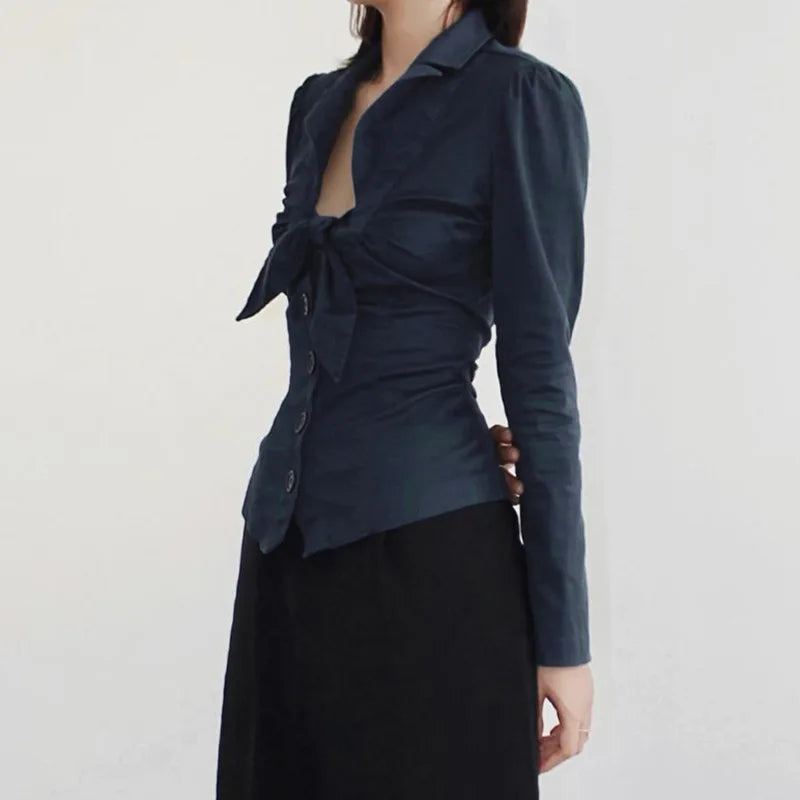 Navy blue top with a tie detail worn by a person on a white background