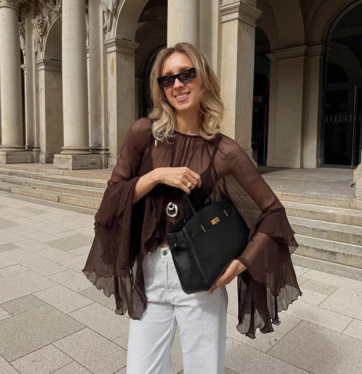 Woman holding a black handbag in front of classical architecture