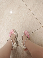 Decorative shoes with floral embellishments on a tiled floor.