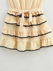 Beige dress with black trim on a white background