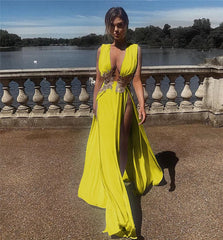 Woman in a bright yellow dress standing outdoors with a scenic background