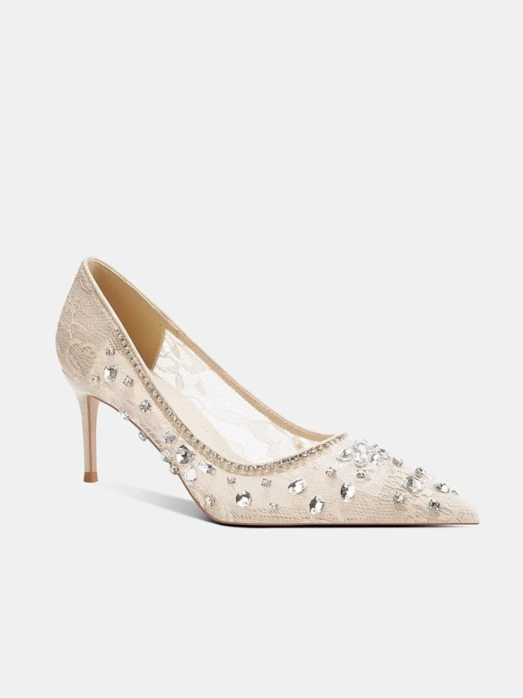 Beige high-heeled shoes with crystal embellishments on a white background