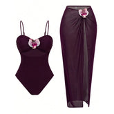 Wine red one-piece swimsuit with adjustable straps and cutout, paired with a high-slit sarong skirt featuring floral applique.