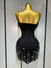 Black dress with silver fringe on a mannequin against a white background