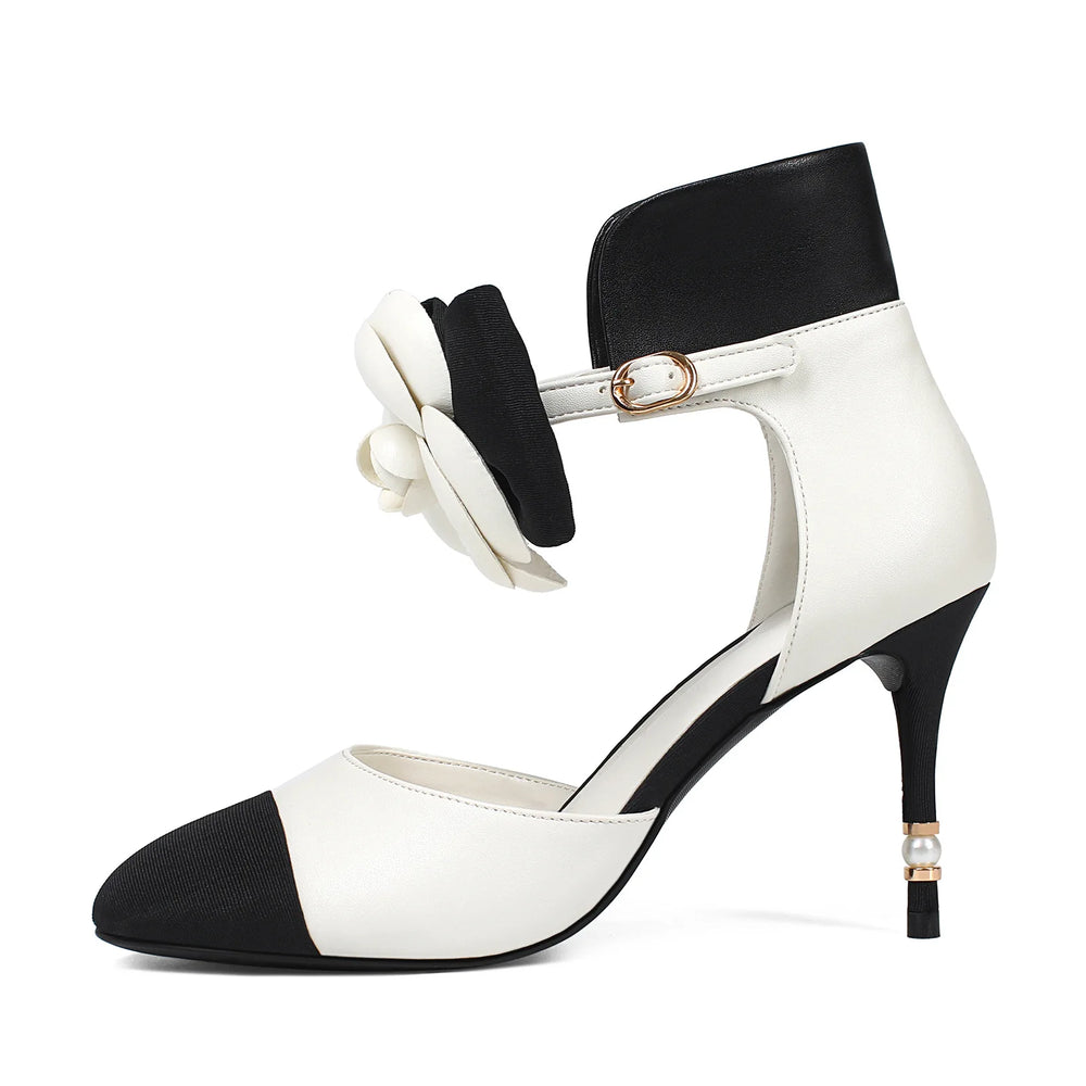 Black and white high-heeled shoes with a bow on a white background