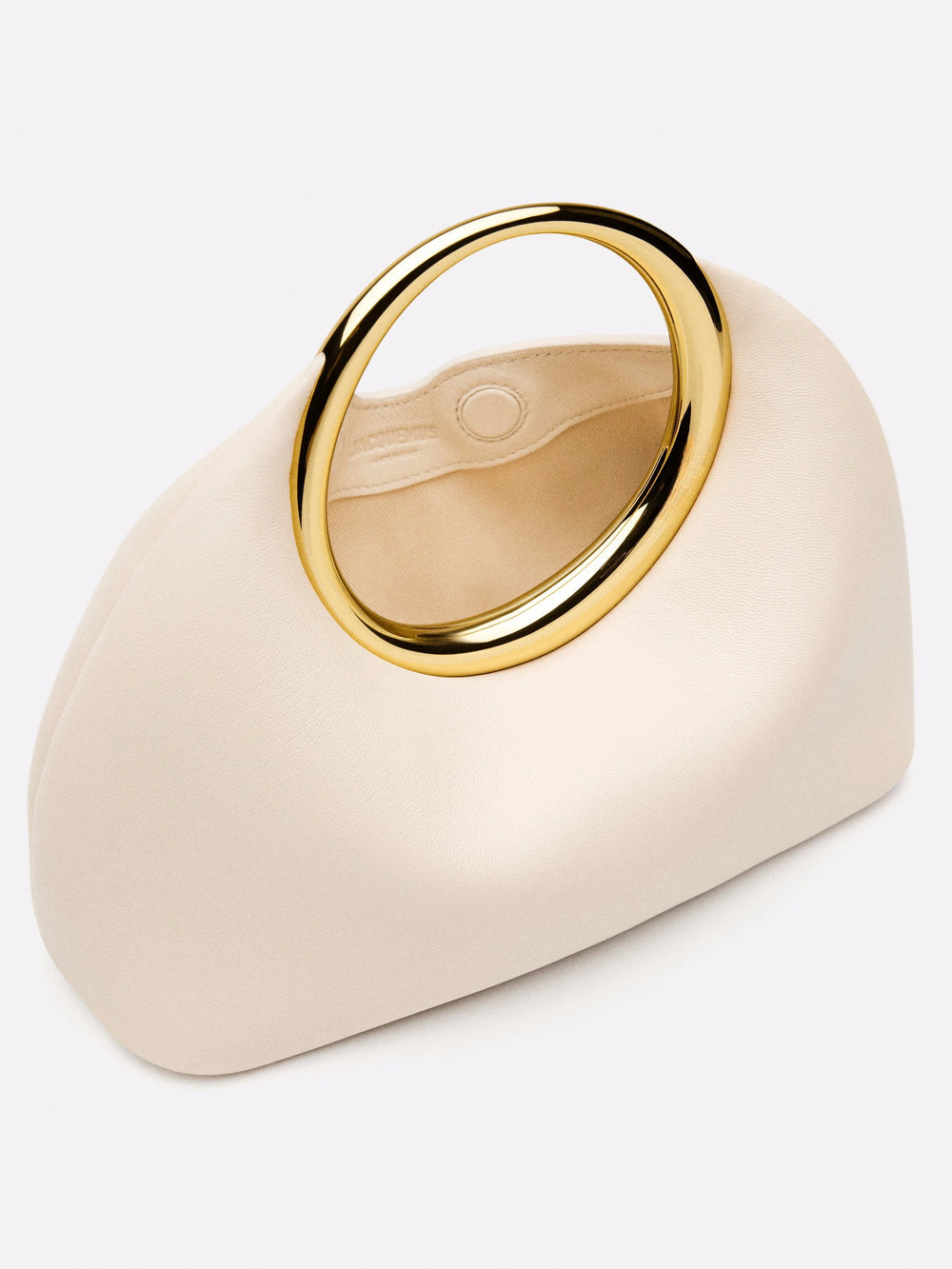 Beige handbag with a gold ring handle on a white background