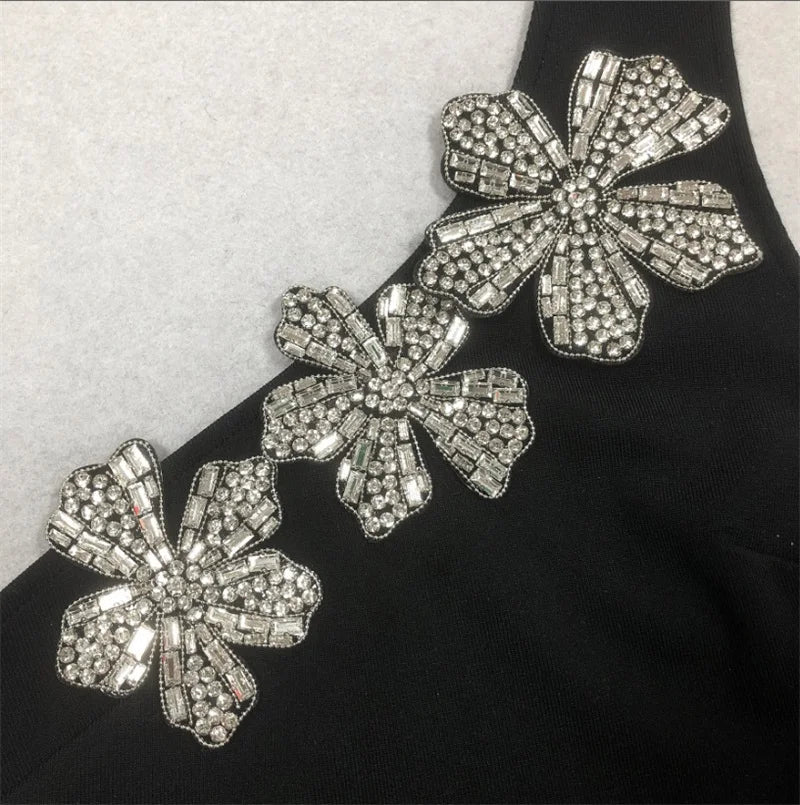 Decorative floral embellishments with rhinestones on a black fabric background