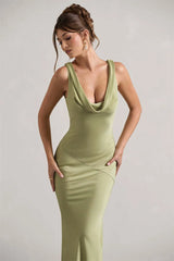 Woman wearing a green dress against a plain background