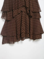 Brown polka dot dress with ruffled layers on a white background