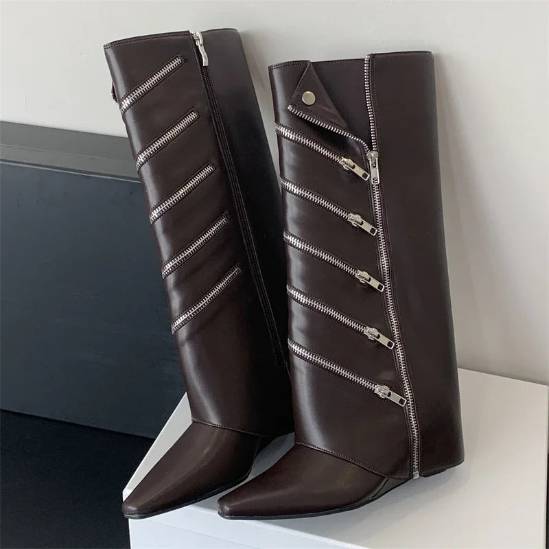 Pair of brown knee-high boots with silver zippers on a white surface.
