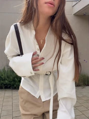 Close-up of a white flared sleeve belted shirt