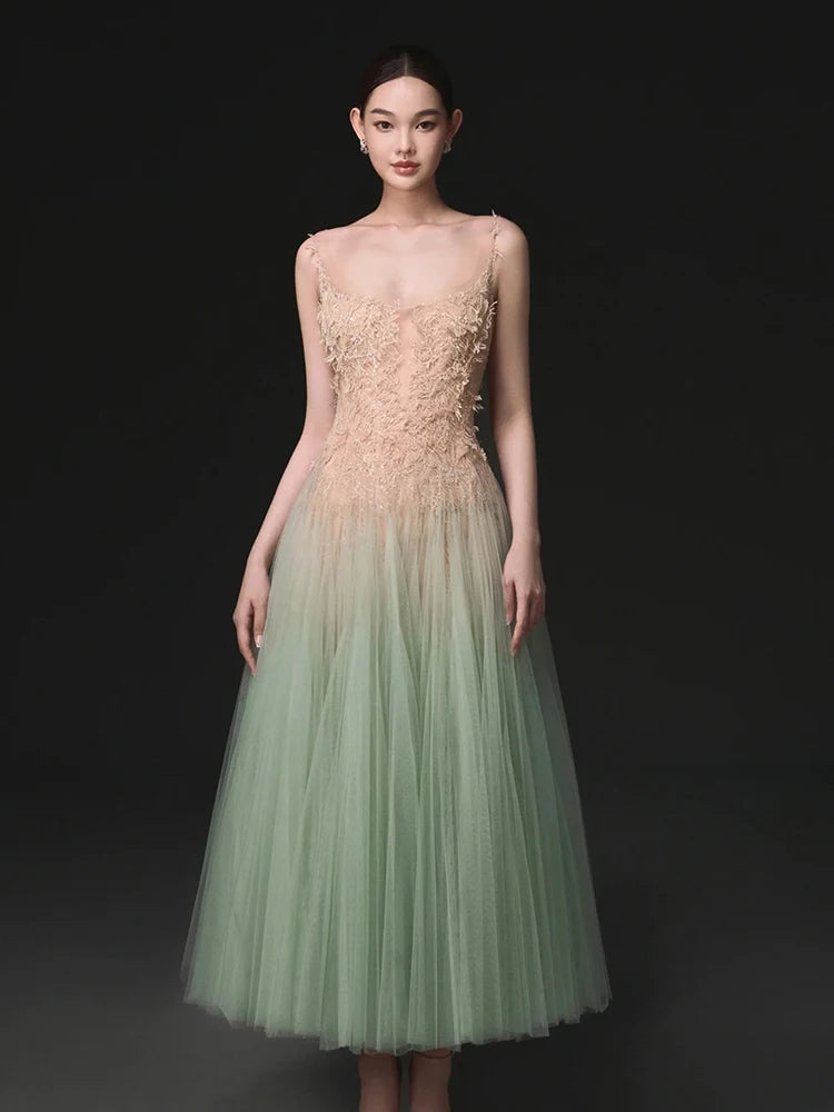 Woman wearing a strapless dress with a gradient from beige to green on a black background