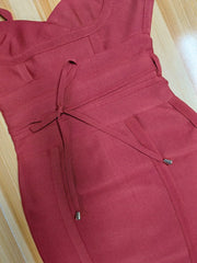 Maroon dress with a tie waist on a wooden surface