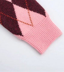 Pink and red argyle patterned fabric on a light gray background