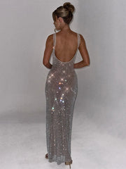 Woman wearing a sparkly silver evening gown against a plain background