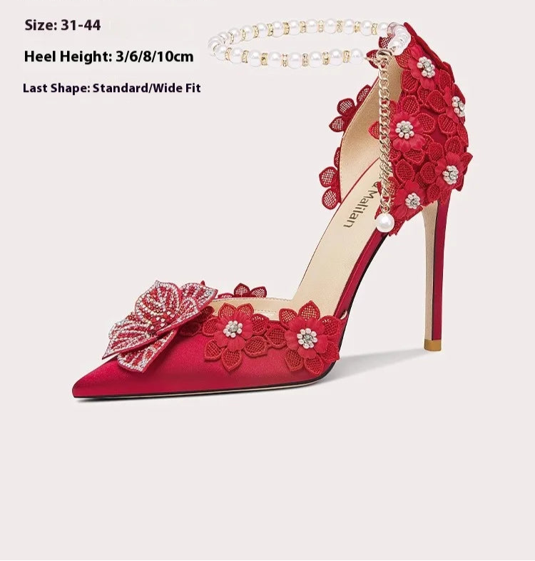 Red high-heeled shoe with floral decorations on a light pink background