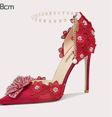 Red high-heeled shoe with floral decorations on a white background