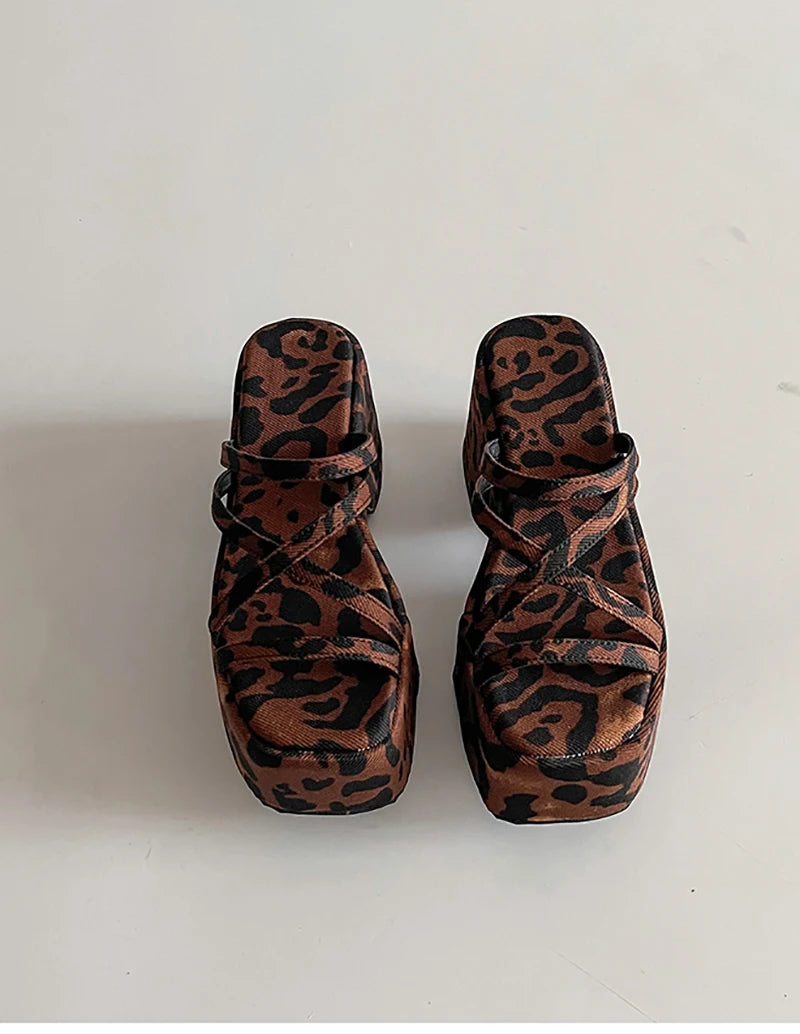 Pair of leopard print sandals on a white background
