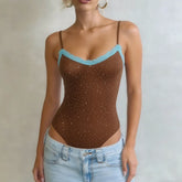 Brown bodysuit with blue lace trim worn by a person against a neutral background