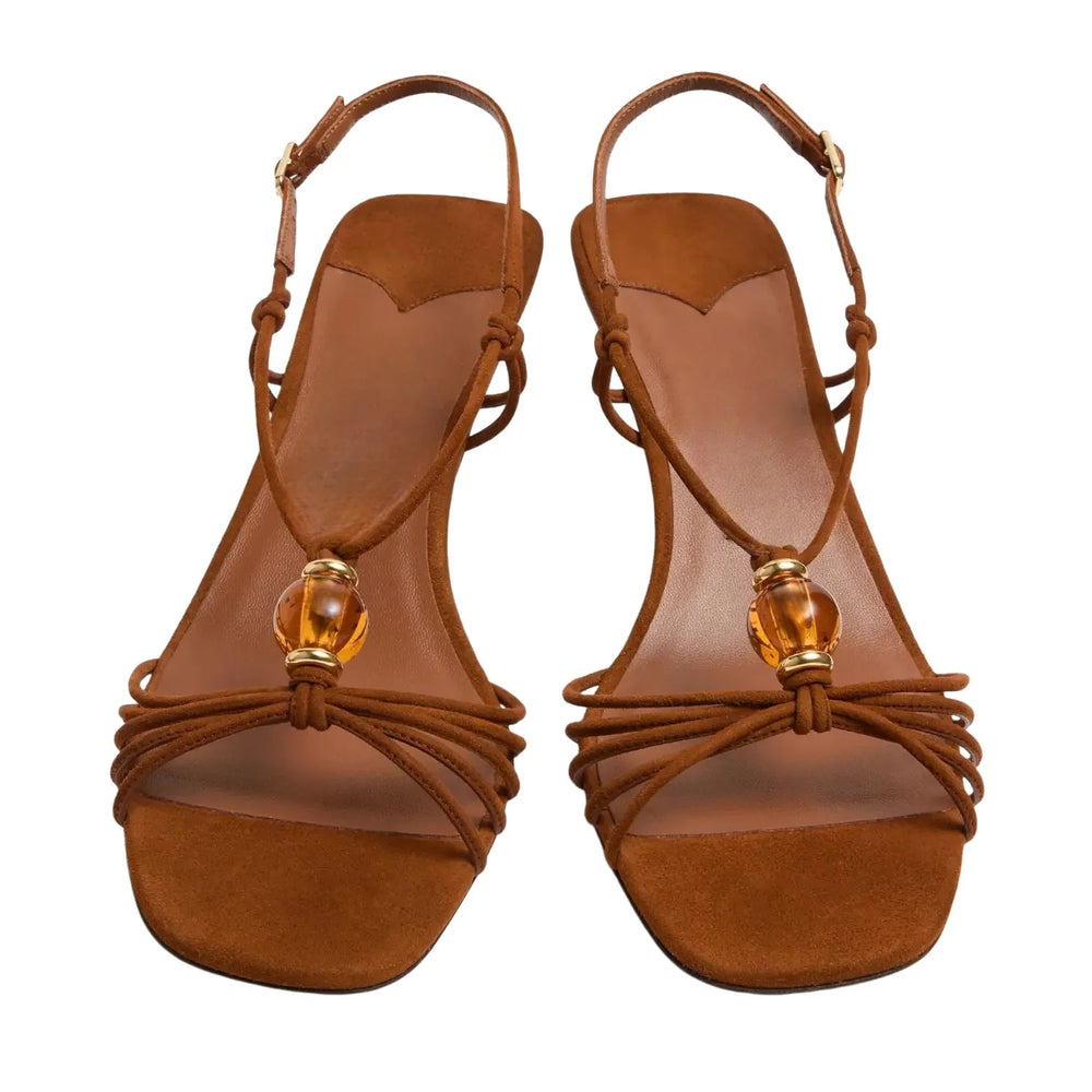 Close-up view of brown suede slingback heels showing beaded detail.