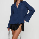 Woman wearing a blue blouse and black shorts