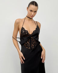 Woman wearing a black lace dress against a plain background