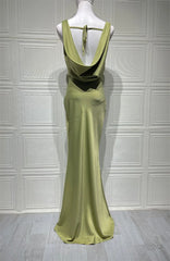Green evening gown on a mannequin against a white paneled wall.
