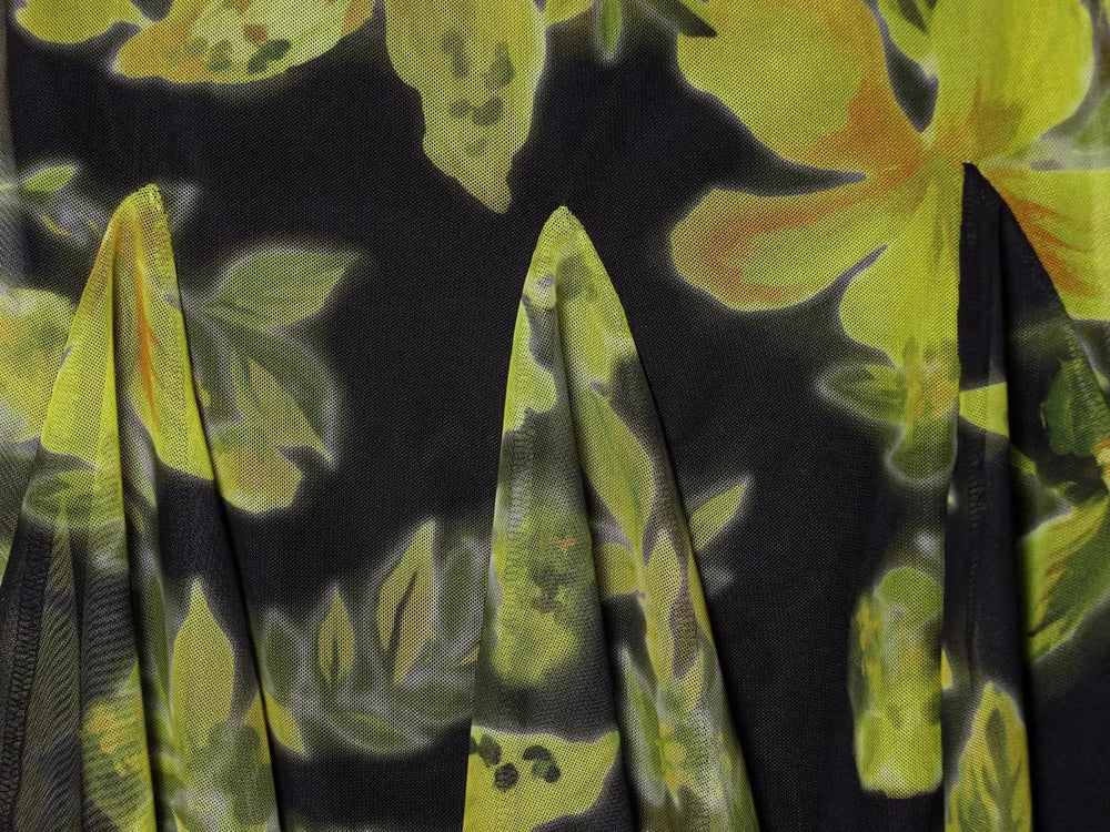 Detail of the pleated skirt and floral print on a mesh dress