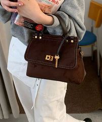 Brown handbag held by a person in a casual setting